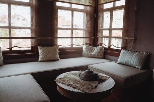 front view of divan with several pillows in front of window