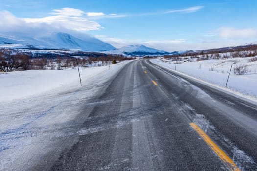 A beautiful view of the frozen road on a cold winter day in Norway