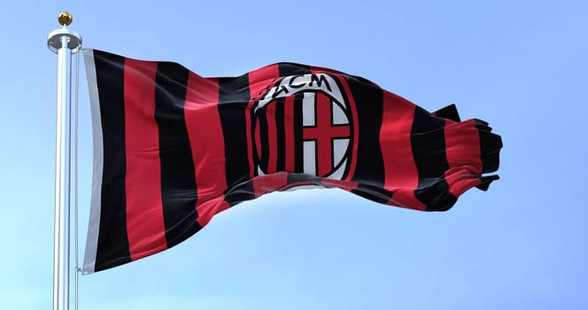 Milan, Italy, July 2022: The flag of A.C. Milan waving in the wind on a clear day. Milan is a professional football club based in Milan, Italy