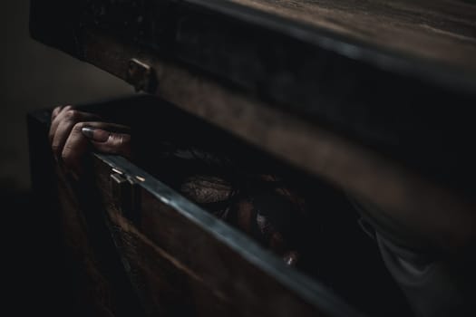 Horror ghost woman. Asian ghost horror creepy scary hair covering face and eye lying in the old treasure chest she look at camera, female makeup terror zombie face, murder, Happy Halloween day concept