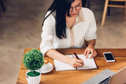 Business young women lifestyle freelance working using laptop computer and he write book note order while sitting outdoor modern loft cafe shop, Businesswoman making notes notepad planning schedule