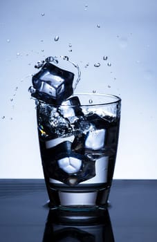 The image of pouring drinking water, into a glass, that makes one feel refreshed on blurred white background, Splashing water, Sparkling water