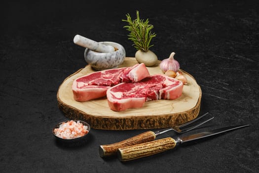 Raw fresh lamb double loin chop with meat fork, herb and spices