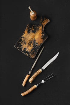 Overhead view of empty vintage wooden cutting board and knife with fork for steak