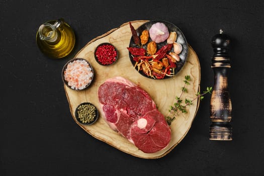 Top view of raw fresh lamb center cut leg steak with spice on wooden slab