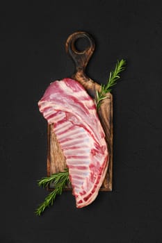 Top view of raw fresh lamb ribs, uncut on wooden serving board