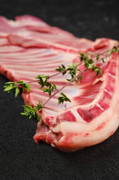 Closeup view of raw fresh lamb ribs, uncut with spices and herbs
