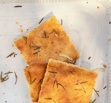 Freshly baked homemade apulian focaccia cut in slices close up. Barese focaccia with rosemary, extra virgin olive oil and salt flakes. Italian Mediterranean traditional food