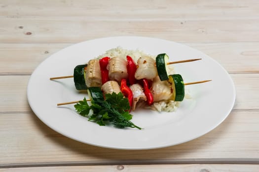 Grilled fish and vegetables on skewer with boiled rice
