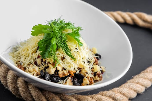 Plate of salad with beetroot, prune, walnut and cheese. Closeup view.