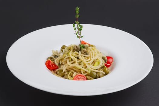 Traditional lenten spaghetti with shallot, tomato, rosemary and olives on a plate