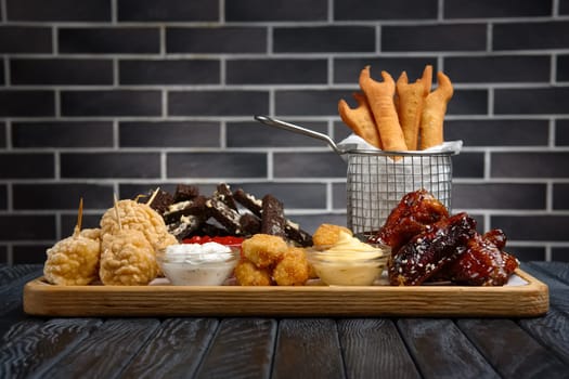Large plate with a wide selection of snacks for beer in bar. Various salty and spicy appetizers.