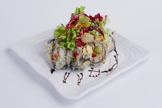 Spring rolls in omelet with fresh salad on a plate