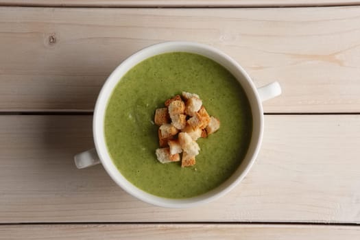Plate of pea soup puree with crackers, top view