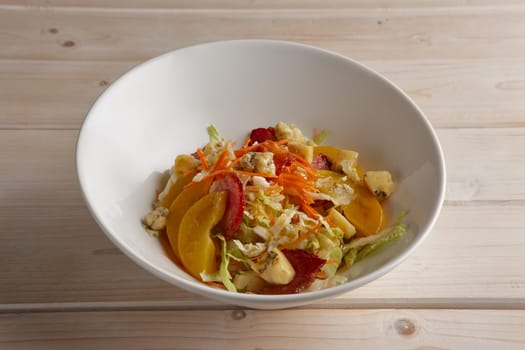Portion of salad with bacon, cabbage, tomato and blue cheese on a plate