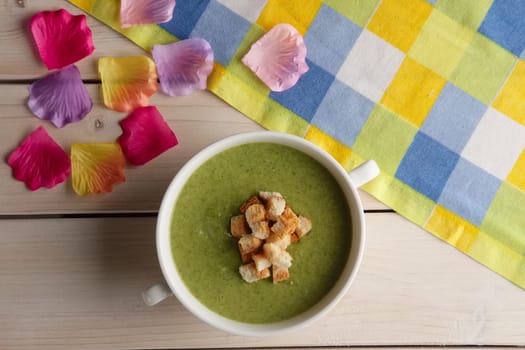 Plate of pea soup puree with crackers, top view