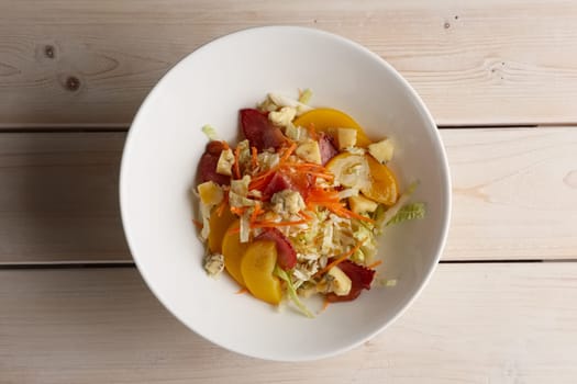 Portion of salad with bacon, cabbage, tomato and blue cheese, top view