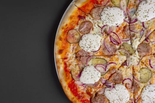 Top view of pizza with sausage, pickled cucumber, onion and horseradish. Place for text
