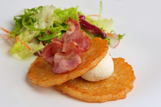 Traditional russian draniki with bacon and salad