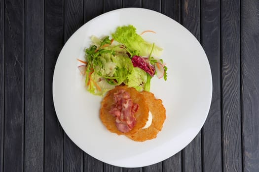 Traditional russian draniki with bacon and salad. Top view.