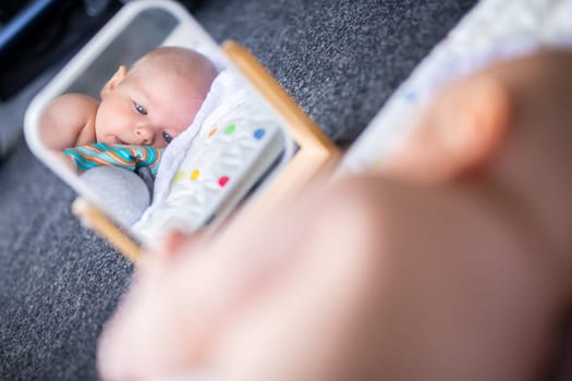 Beautiful shot of mirror reflectiona of cute baby boy playing with toys