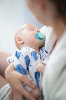 Young mother is holding her little baby