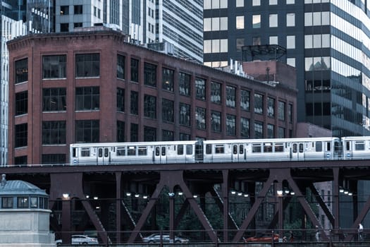 Chicago : October 10, 2018, Train on elevated tracks within buildings at the Loop, Glass and Steel bridge between buildings - Chicago City Center - Chicago, Illinois, USA