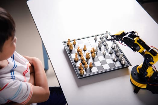 Asian little boy is playing chess with robot machine arm, STEM education E-learning, Funny children learning successful getting a lesson control robot arm, Technology science education concept