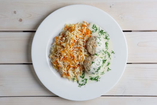 Top view of plate with meatballs with rice and carrot.