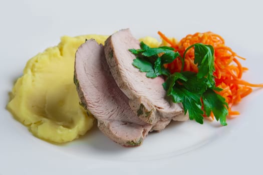 plate with oven made pork with mashed potato and spicy carrot
