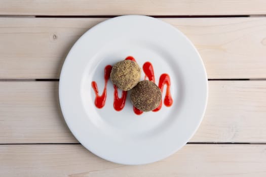Chocolate truffles with biscuit powder. Rum balls and raspberry jam. Top view.