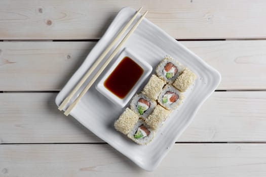 Maki Sushi - Roll with Smoked Salmon, Cream Cheese, Salad Leaf and Avocado inside. Sesame outside.
