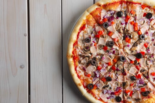 Top view of part of pizza with ham, olives, pepper and mushroom