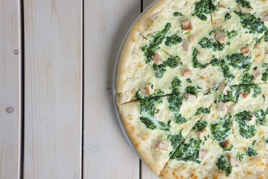 Top view of half of pizza with spinach and chicken. Copy paste space.