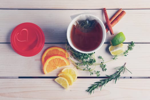 Top view of table with herb tea with orange, lime and lemon in take away cup