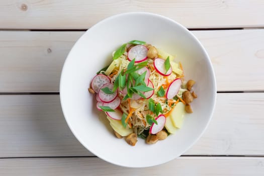 Salad with radish, cabbage, mushroom and potato. Top view.