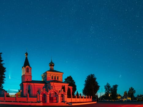 Korma Village, Dobrush District, Belarus. Comet Neowise C2020f3 In Night Starry Sky Above St. John The Korma Convent Church In Korma Village. Famous Orthodox Church And Historic Heritage.