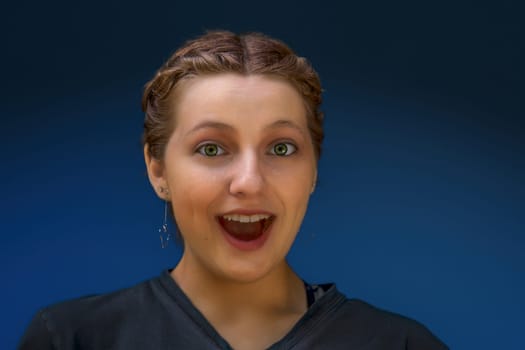 amazed young woman open mouth reacting surprise astonished emotional scream excited girl on blue background