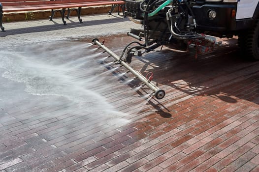 A special machine washes city paths and roads with water. High quality photo
