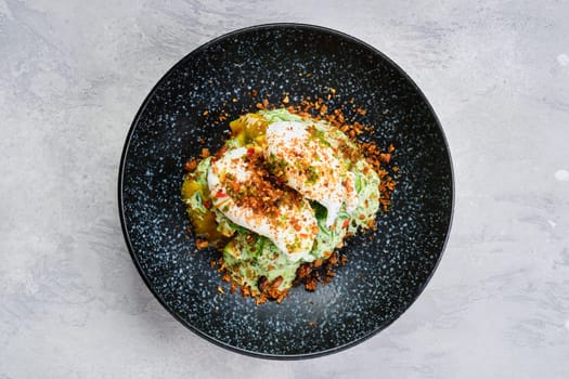 Top view of poached egg on a bun with avocado on a plate