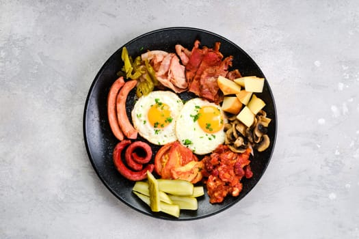 Brekfast plate. Fried egg, sausage, champignon, bacon, bean ragout, ham, cheddar, tomato and bell pepper