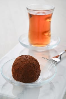 Closeup view of chocolate biscuit dough cake and a cup of tea on a table