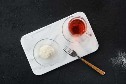 Top view of coconut biscuit dough cake and a cup of tea on a table