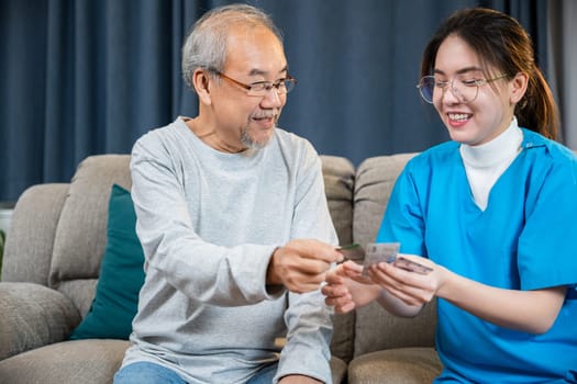 Woman nurse caregiver show prescription drug to senior man at nursing home, Doctor with physician visit senior male patient consult medicine dosage at house in living room, Healthcare worker support