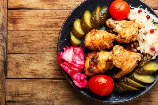 Fried chicken meat and a side dish of pickles. English cuisine.