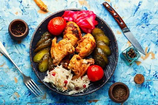 Fried chicken meat and a side dish of pickles. English cuisine.