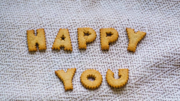 Cookies in the form of the alphabet prospect. Happy from homemade cookies on dark white background. Happy cookies concept
