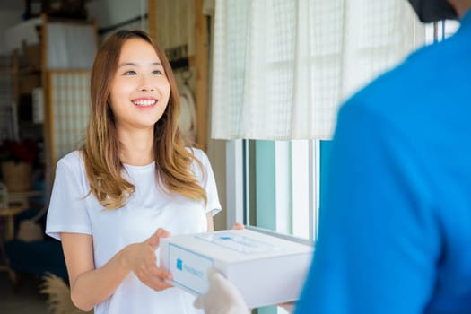 Asian woman sick she receive medication first aid pharmacy box hospital delivery service, Delivery man give medicine drug store to patient female at front home, healthcare medicine online business