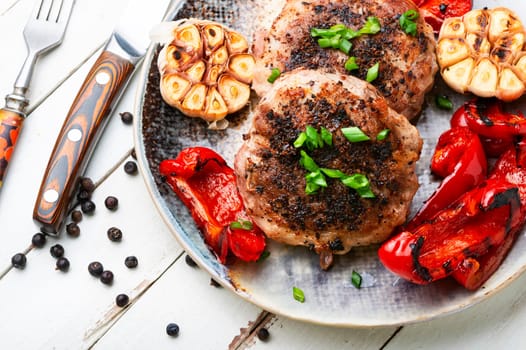 Roasted beef steak with minced meat and garnish of roasted bell pepper and garlic