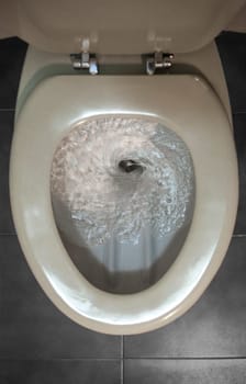 Old regular toilet flushing excessive use of water. Low-efficiency toilets
